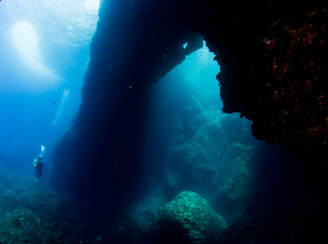 Photo of a diver admiring the arch of the Blue Hole taken on a guided dive on Gozo Malta